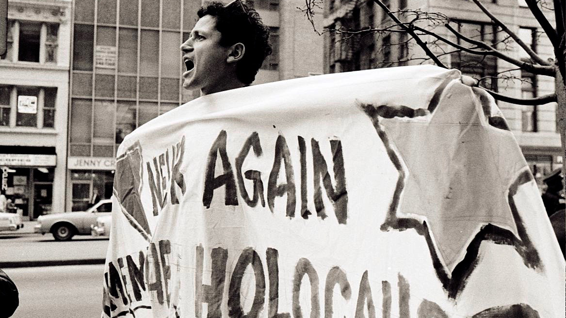 Chicago AIDS activist Danny Sotomayor holding a banner during a protest, April 1990. Credit: Lisa Howe-Ebright, photographer.